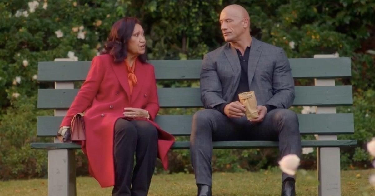 Dwayne Johnson and his Mom sitting on a bench together 