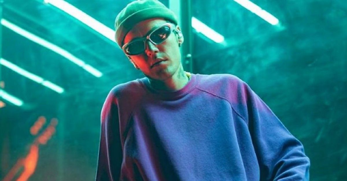 Justin Bieber wearing sunglasses and beanie in blue overtoned image