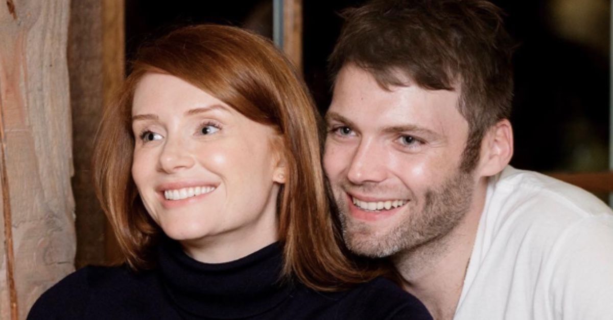 A close-up of Bryce Dallas Howard and her husband Seth Gabel sitting next to her. Both are smiling and look away from the camera.