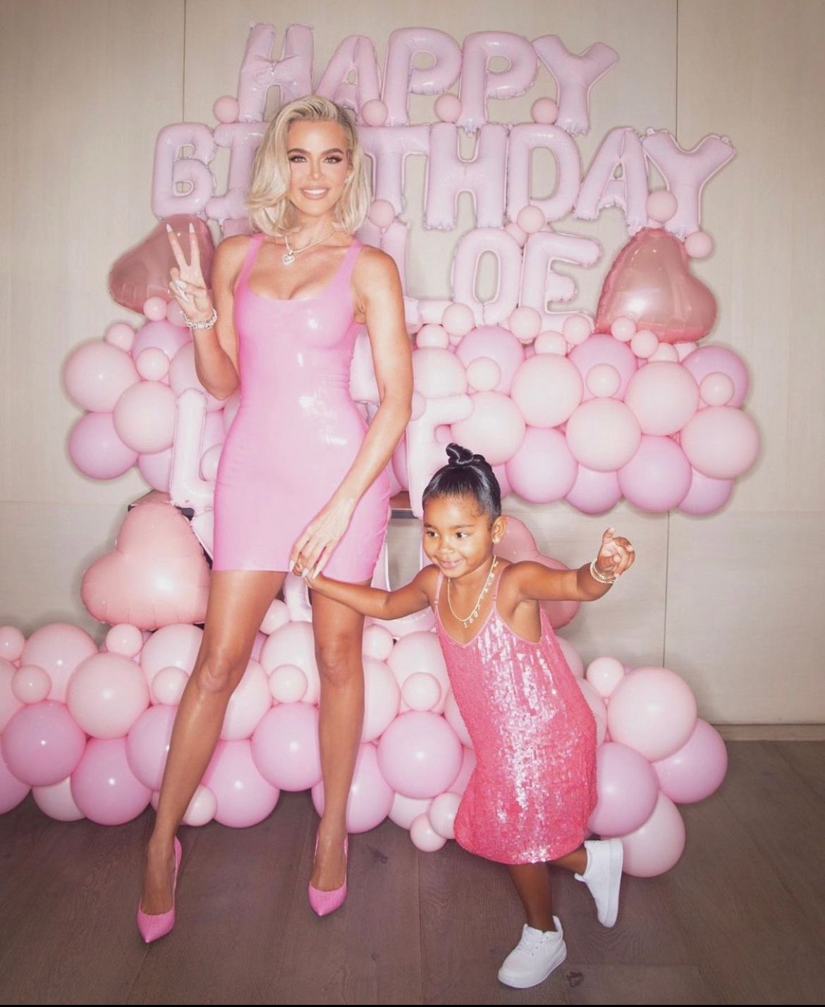Khloe Kardashian and True Thompson in pink dresses