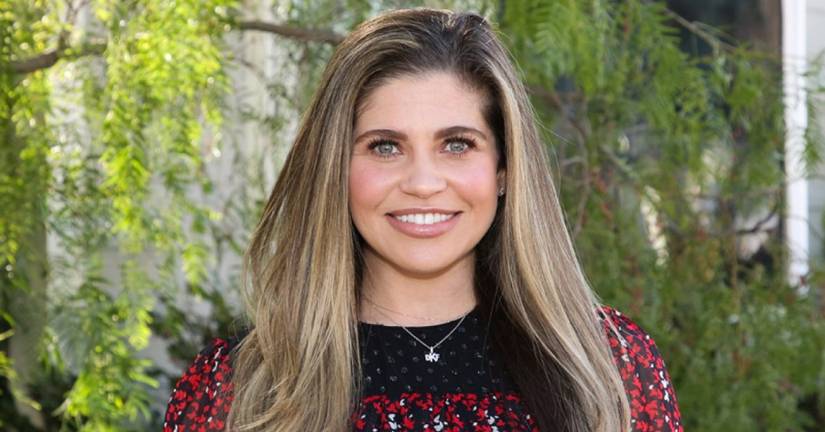 Danielle Fishel Karp smiling in front of greenery
