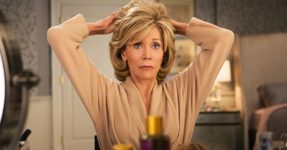Jane Fonda as Grace Hanson.The actress is looking at her reflection in the mirror, passing her fingers through her hair.