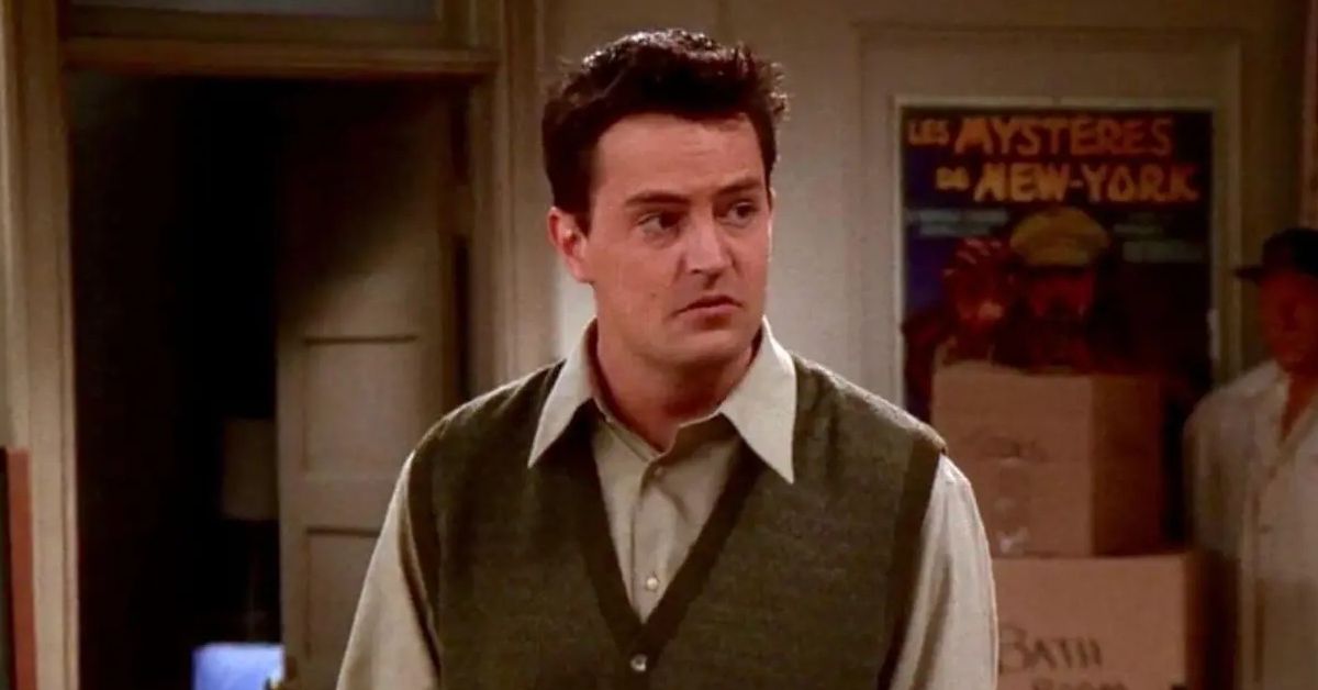 Matthew Perry wears a sweater vest and a shirt as Chandler Bing on Friends.