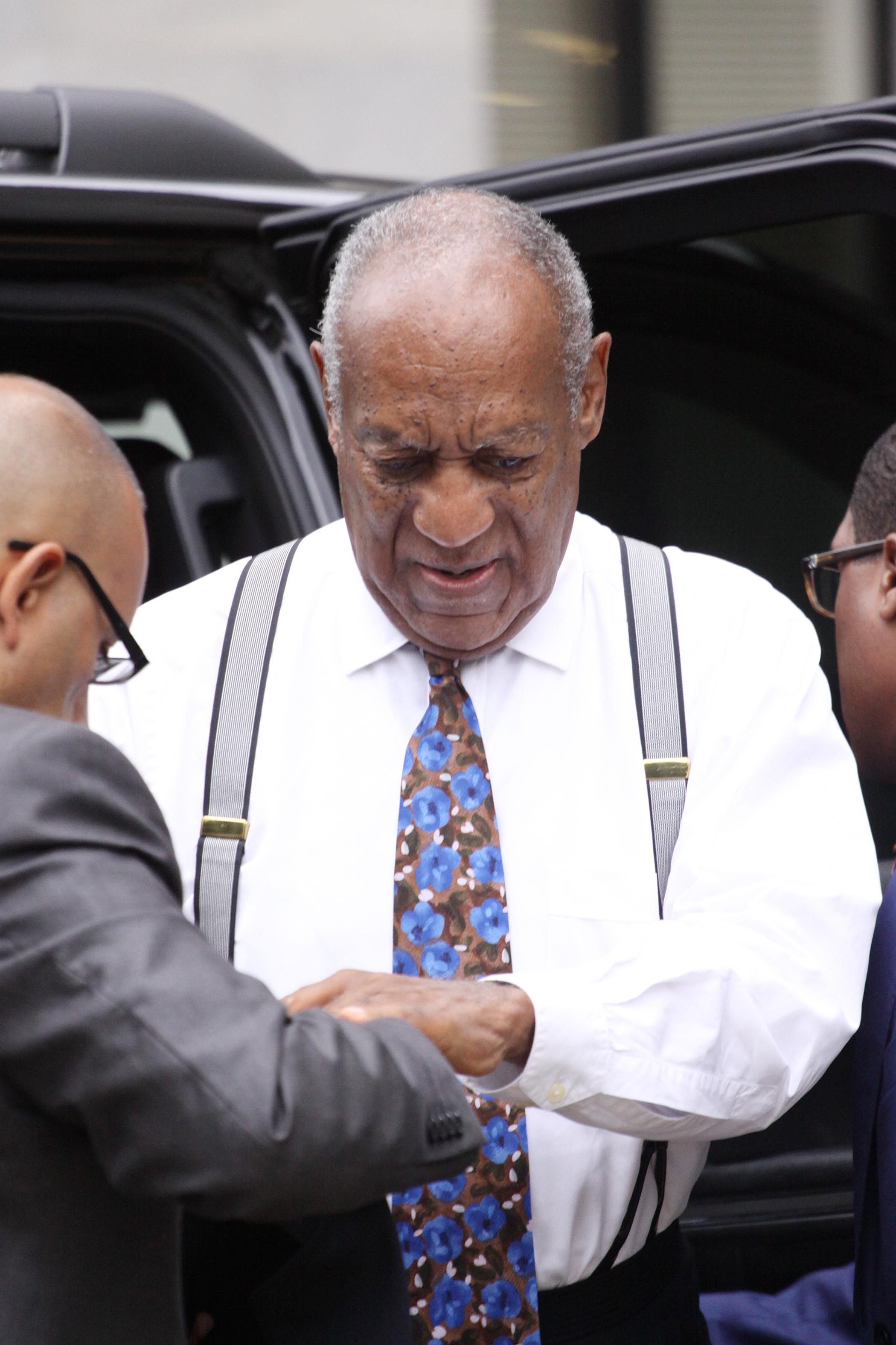 Bill Cosby getting out of a vehicle