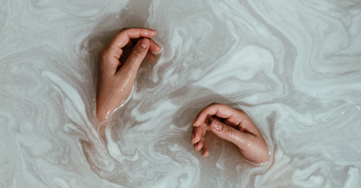 hands in milky water