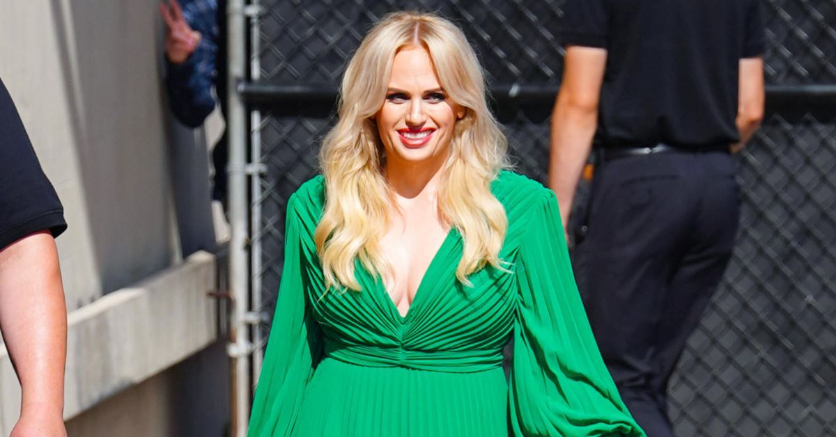 Rebel Wilson smiling in a green dress