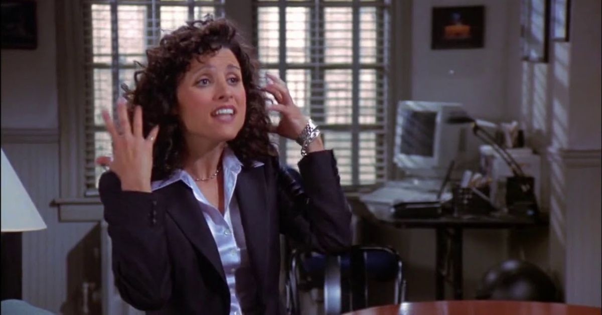 Elaine Benes holding up her hands and smiling on Seinfeld
