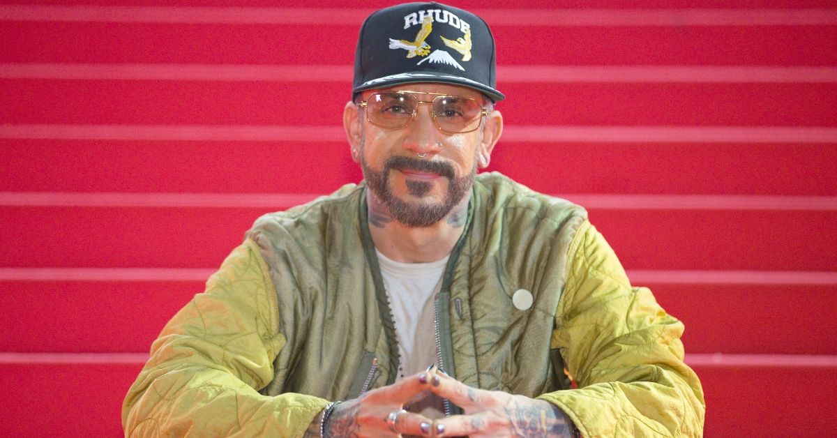 aj mclean in front of a red backdrop