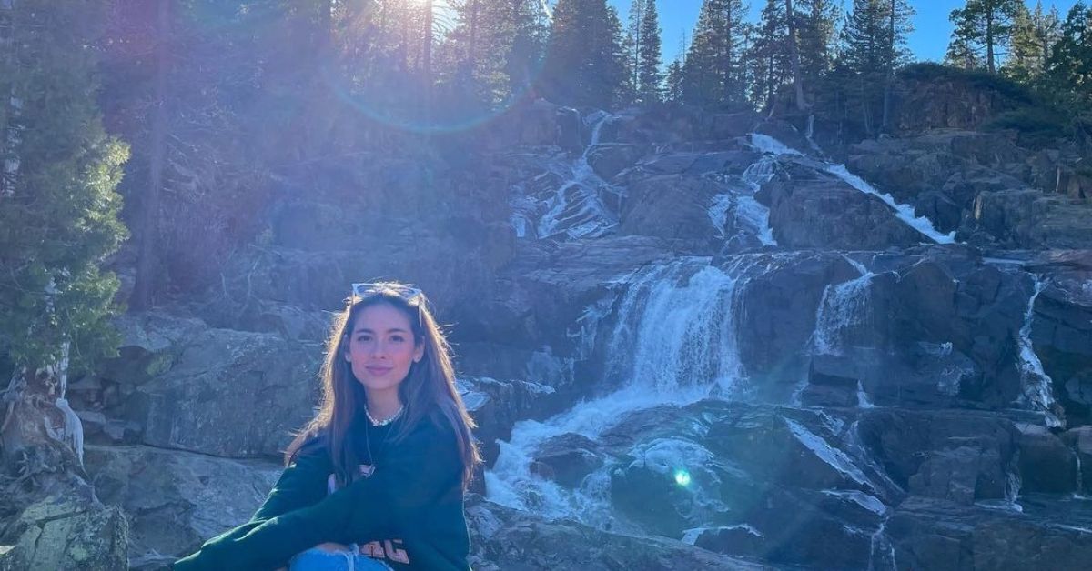 Haley Pullos sitting by a water fall