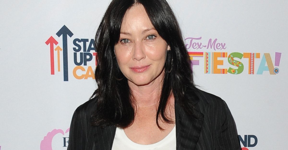 Shannen Doherty standing looking serious
