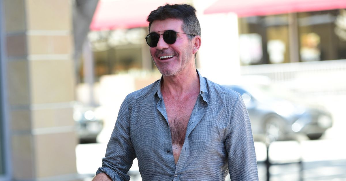 Simon Cowell smiling and standing outside