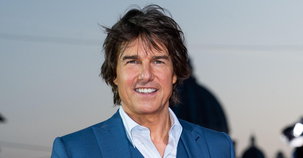 Tom Cruise smiles on the red carpet in blue suit