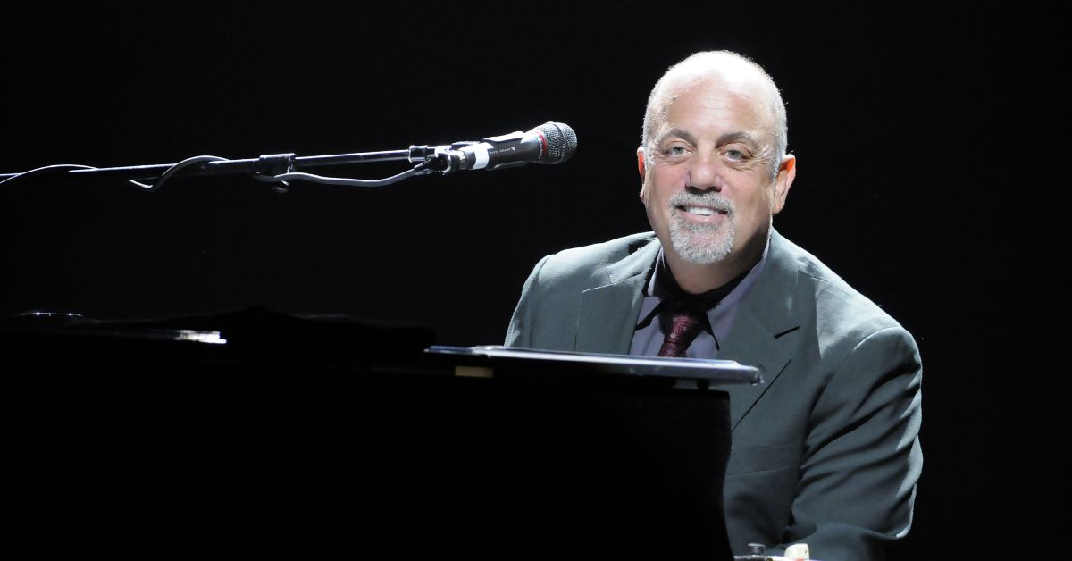 Billy Joel smiling as he plays piano