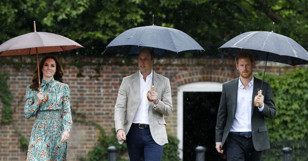 Prince William, Prince Harry, and Princess Kate Middleton holding umbrellas