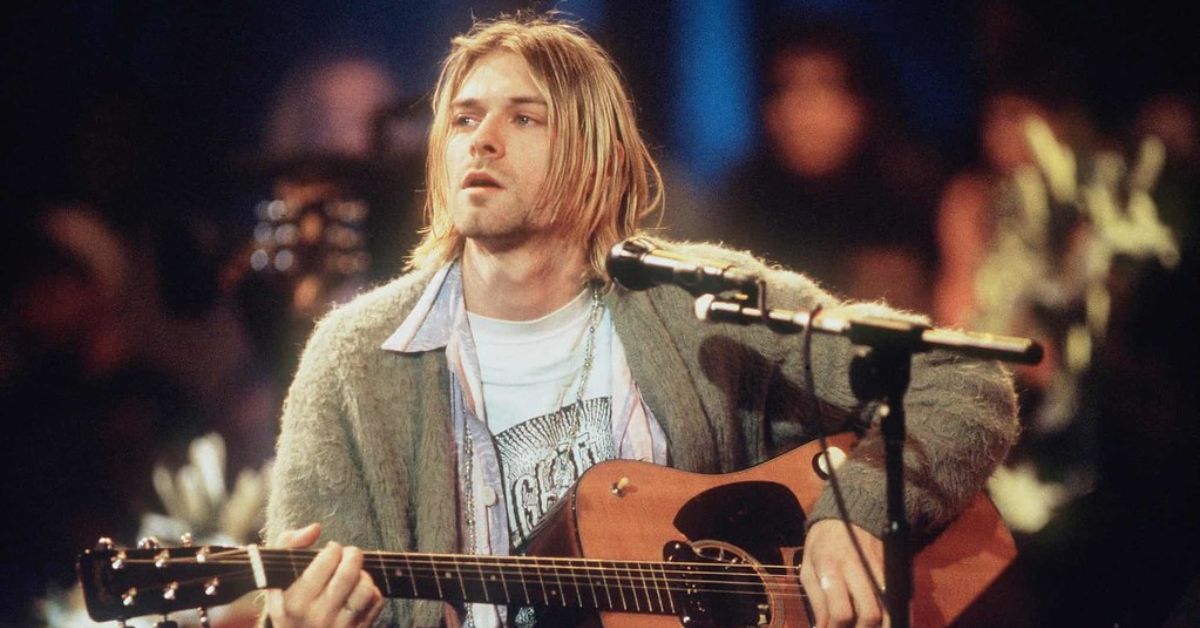 Kurt Cobain looking annoyed while playing guitar in concert