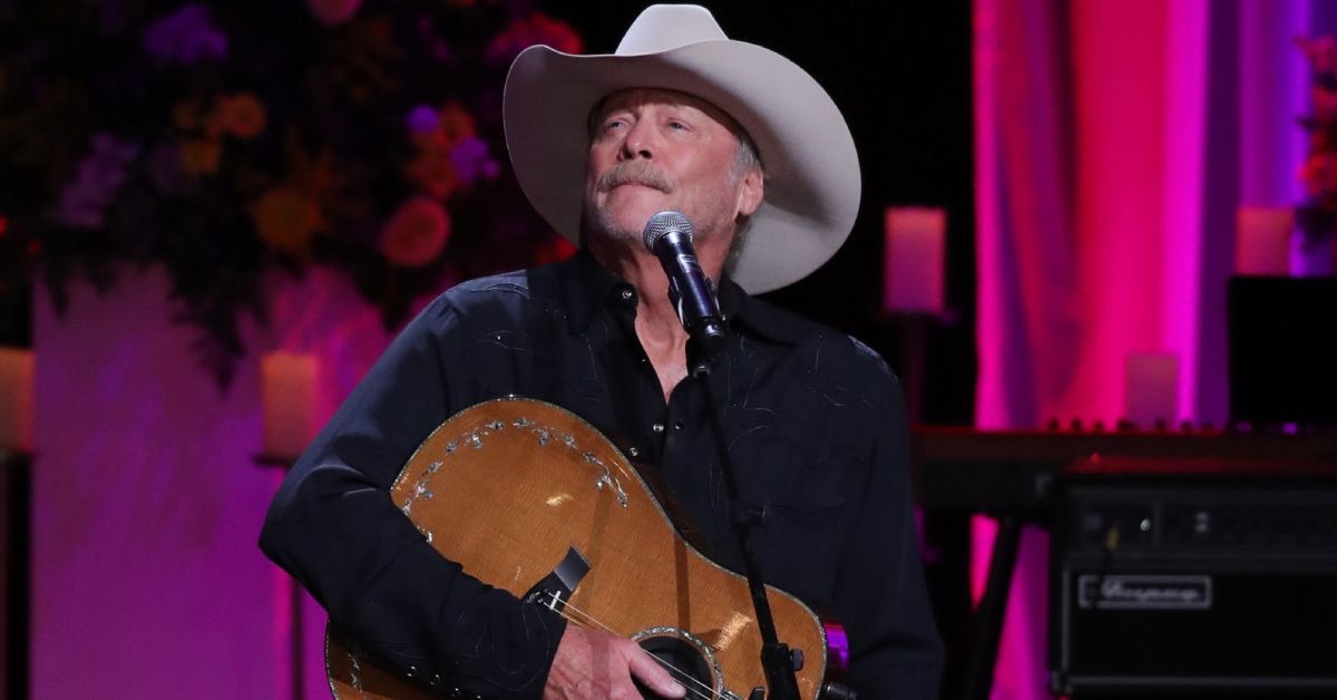 Alan Jackson holding his guitar on stage during a concert