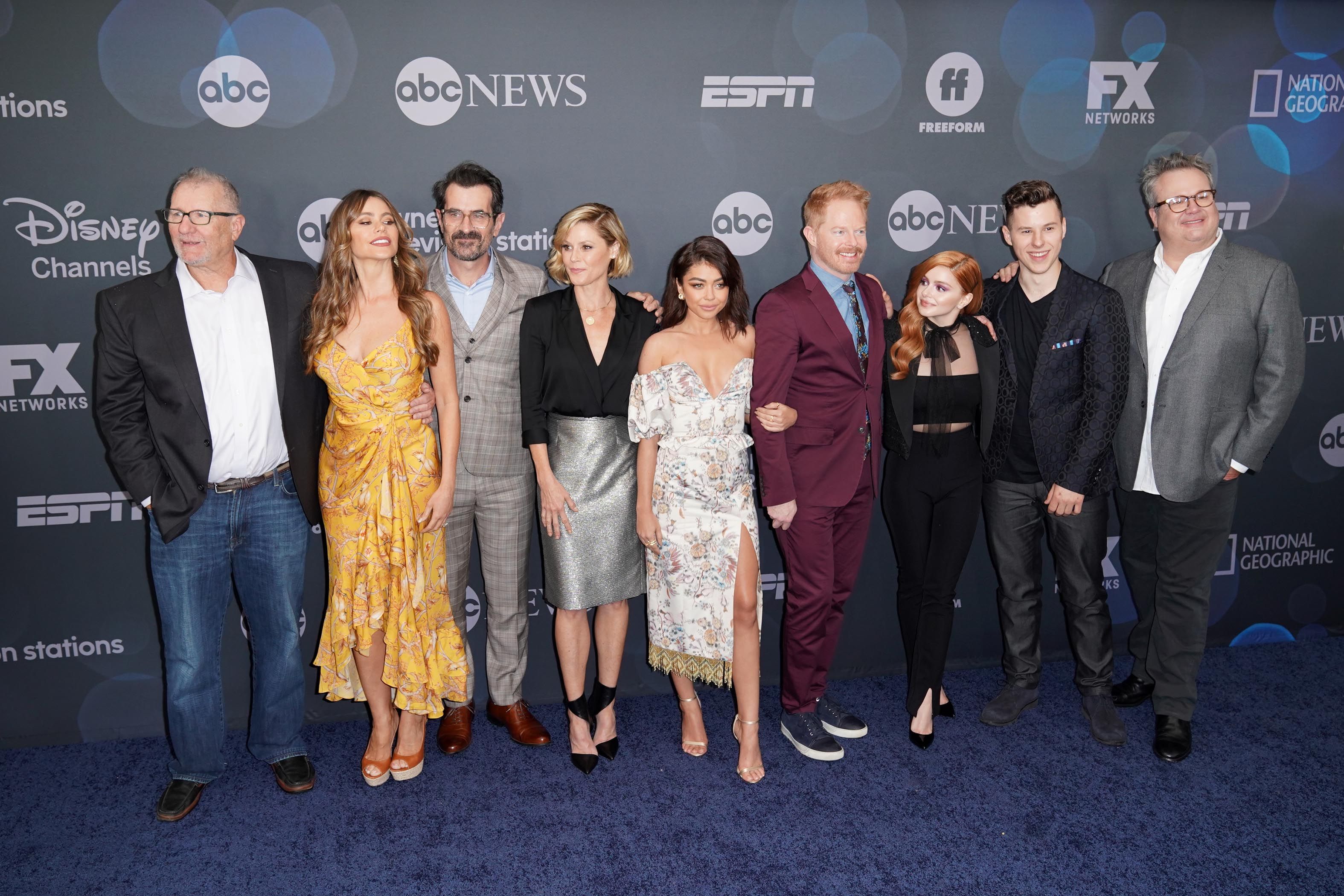 The Modern Family cast taking a photo together at a blue carpet event 