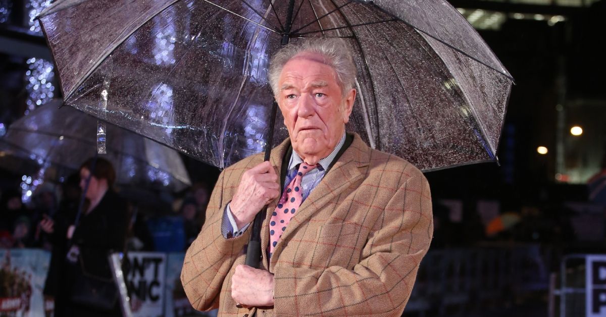 Michael Gambon from Harry Potter holding an umbrella