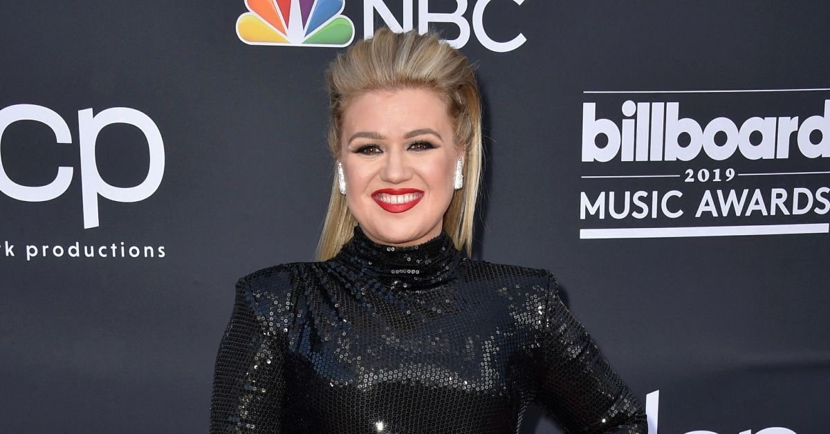 Kelly Clarkson posing in a black dress on the red carpet