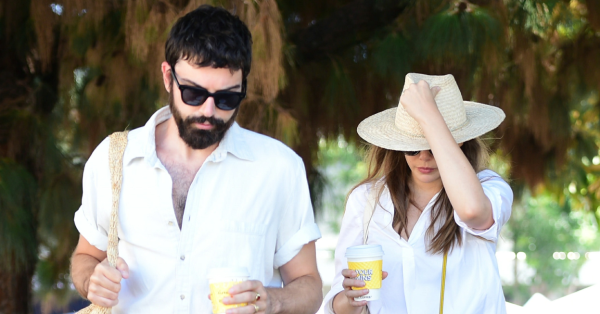 Elizabeth Olsen and Robbie Arnett on a walk together holding coffee