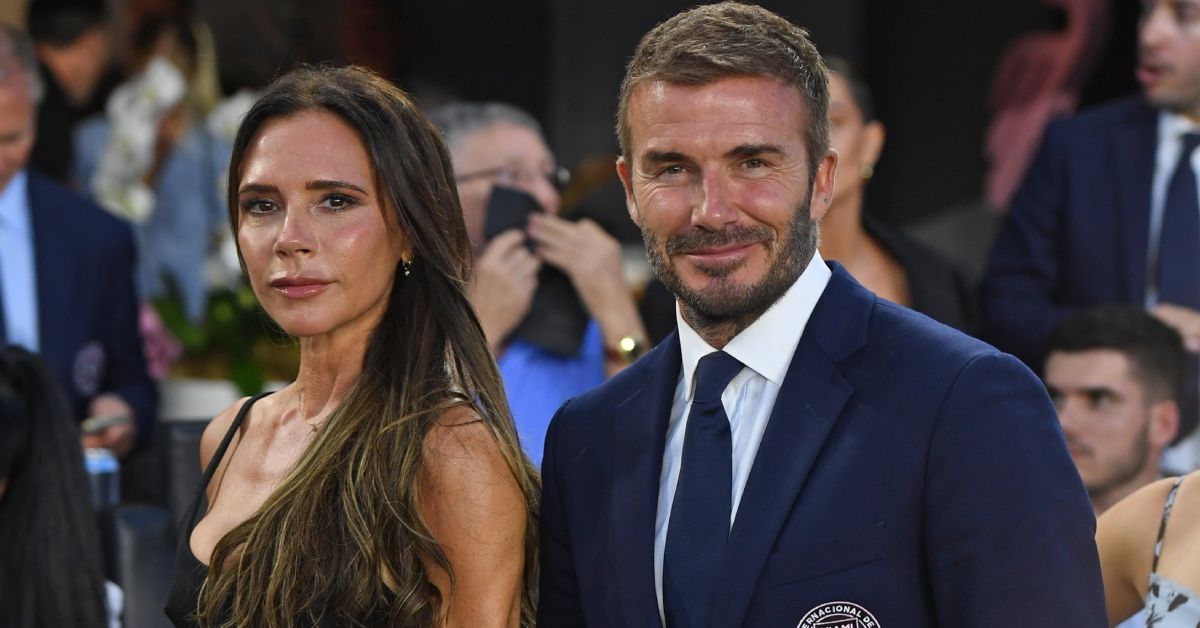 Victoria Beckham looking serious next to David Beckham smiling