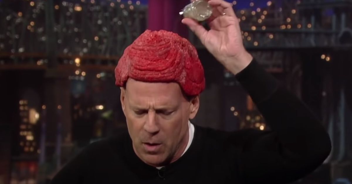 Bruce Willis seasoning a raw meat hat