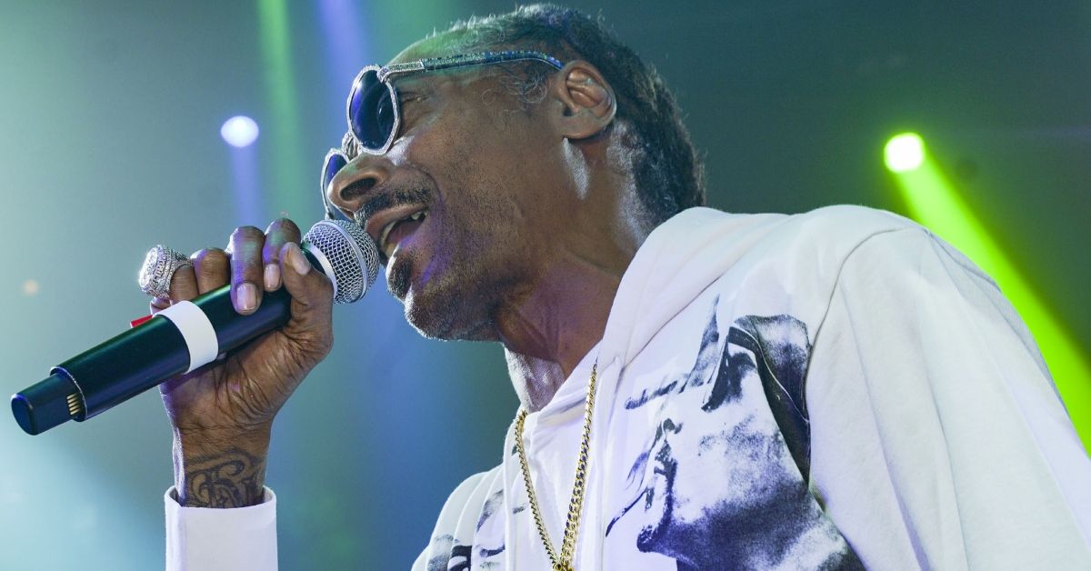 Snoop Dogg performing and holding a microphone