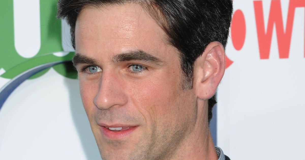 Eddie Cahill smiling on the red carpet of an event