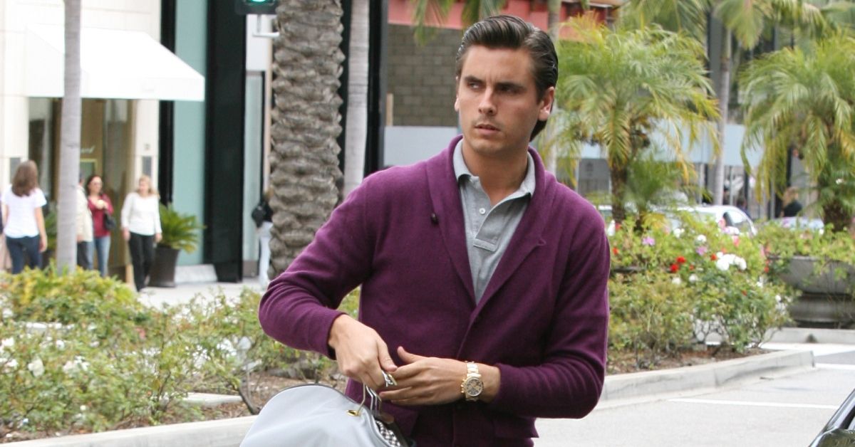 Scott Disick walking and holding dry cleaning 