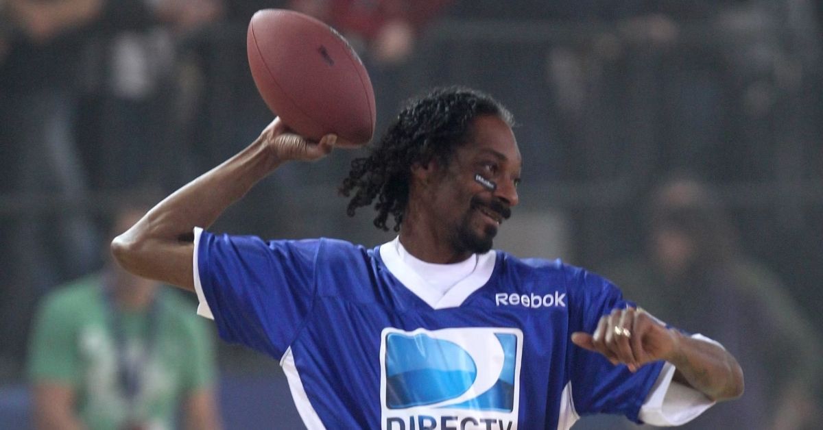Snoop Dogg holding up a football 