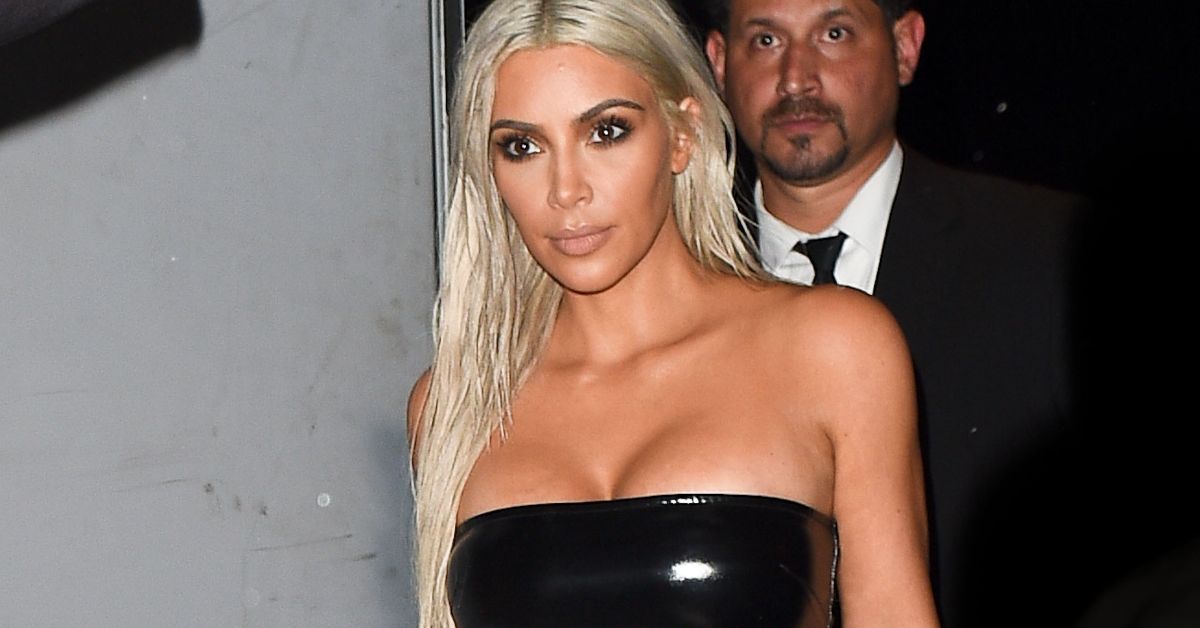 Kim Kardashian walking outside in a black dress