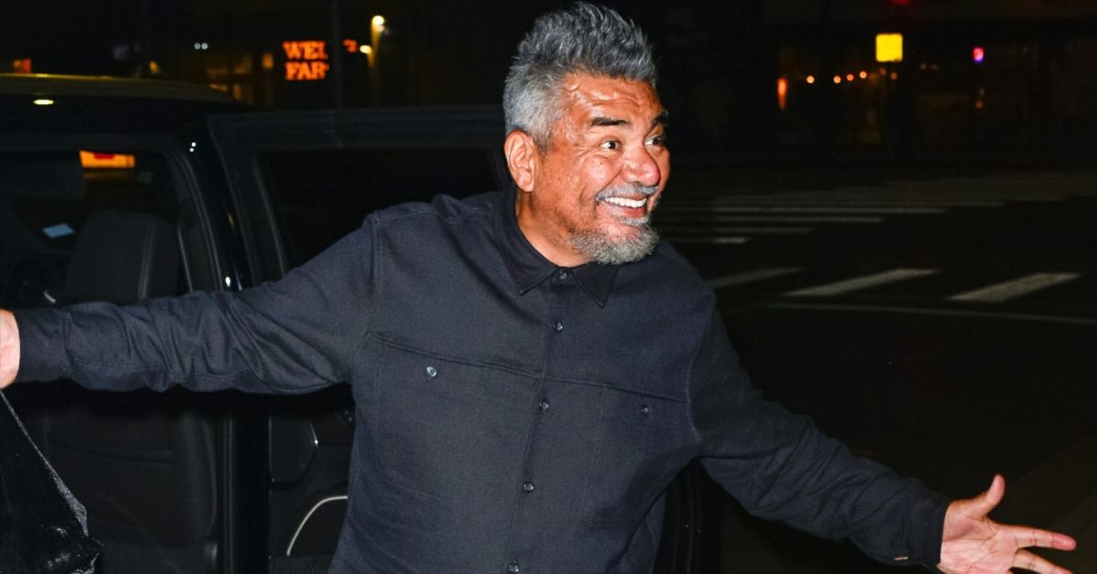 George Lopez smiling and holding out his hands outside