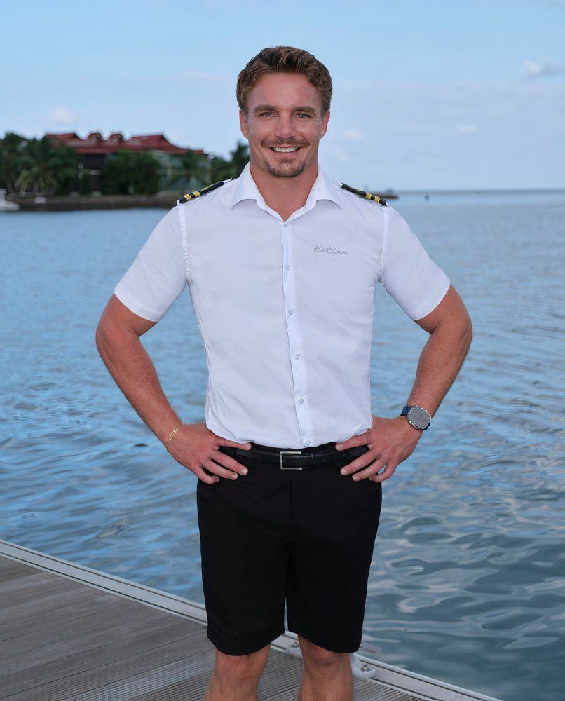 man in white shirt and black shorts with hands on hips