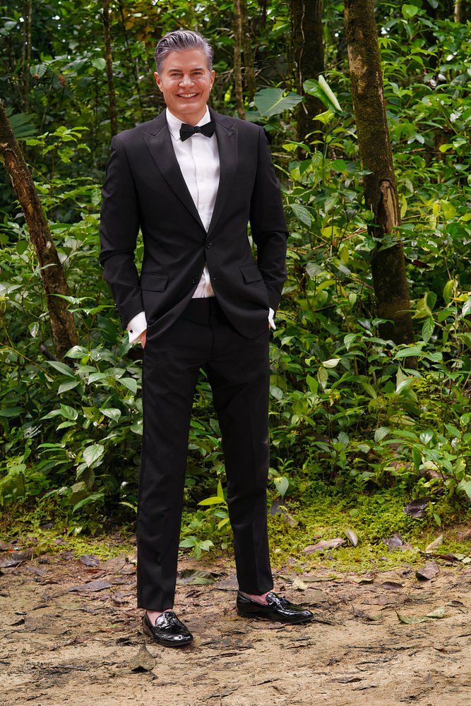 man posing in tuxedo on island