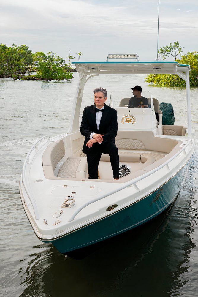 man rides in a boat wearing a tux