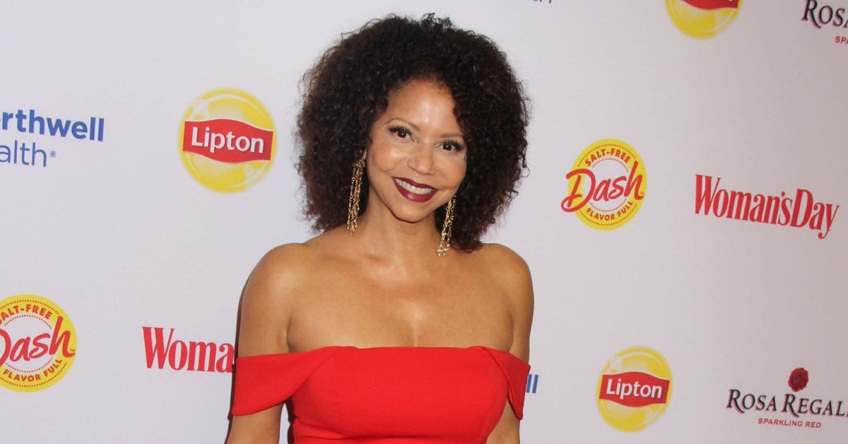 Gloria Reuben smiling and wearing red